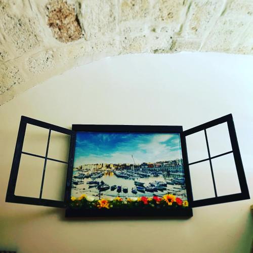 a picture hanging on a wall with two windows at La Torretta di Gigi - soggiorno in torre medievale in Bisceglie