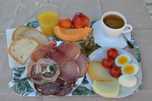 a plate of breakfast food with eggs bread and a cup of coffee at Agriturismo Marinello in Pienza