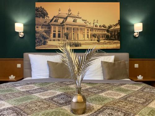 a bedroom with a bed with a vase on a table at Restaurant und Pension Zur Puppenstube in Stolpen