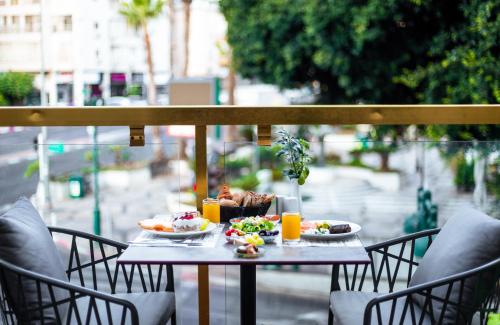 a table with food and drinks on a balcony at Roxon Urban Ramat Gan, Formerly Ramada Ramat Gan in Ramat Gan