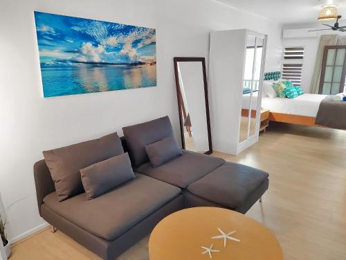 a living room with a couch and a bed at Palm Cove Beach Retreat - 1st Floor in Palm Cove