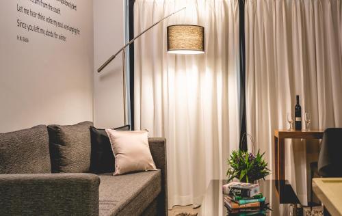 a living room with a couch and a lamp at Roxon Urban Ramat Gan in Ramat Gan