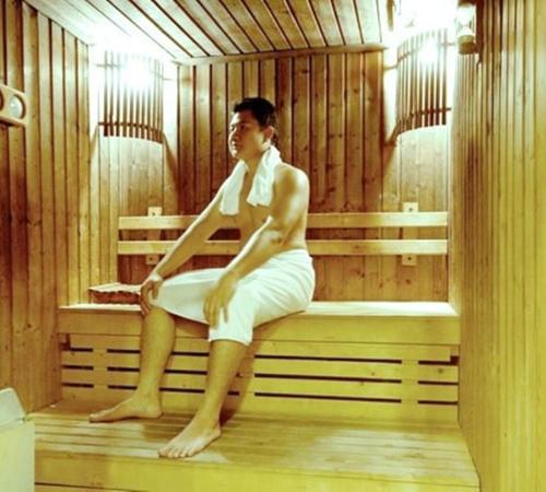 a woman sitting on a bench in a sauna at Lao Plaza Hotel in Vientiane
