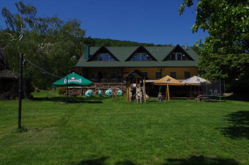 a large house with a playground in the yard at Penzión Prameň in Vinné