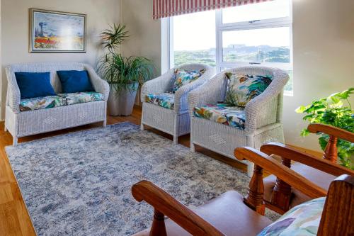 a living room with two chairs and a couch at Aire del Mar Guest House in Gansbaai