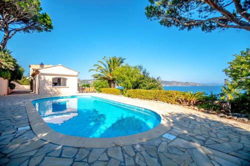 una piscina nel mezzo di un patio con l'oceano sullo sfondo di LUXUEUSE VILLA, INCROYABLE VUE MER, PISCINE a Sainte-Maxime