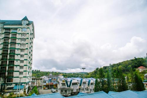 a tall building in a town with a mountain at Wan Alyasa Hotel in Cameron Highlands