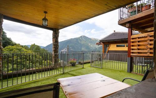 a balcony with a table and a view of a mountain at Balcon del Pirineo Rural Ordesa in Buesa