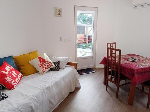 Cette chambre comprend un lit avec des oreillers et une table. dans l'établissement Idéal pied à terre proche Cannes & Sophia, parking, à Mougins