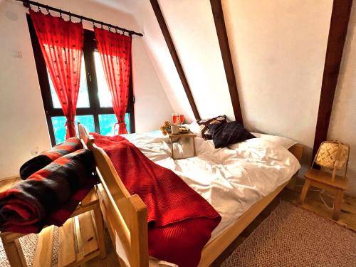 a bedroom with a bed with red curtains and a window at Kuća na Kopaoniku - Rani mraz in Kopaonik