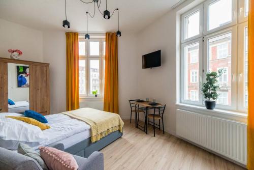 a bedroom with a bed and a chair and a window at Cozy, Small Studio.Great location / Mała Kawalerka in Szczecin