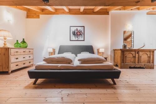 a large bedroom with a bed and a wooden floor at Ferienwohnungen Wiesbauer in Schenna