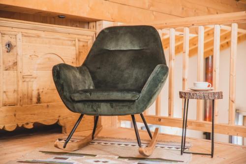 a green chair in a room with a table at Ferienwohnungen Wiesbauer in Schenna