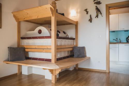 a wooden bunk bed in a room with a kitchen at Ferienwohnungen Wiesbauer in Schenna