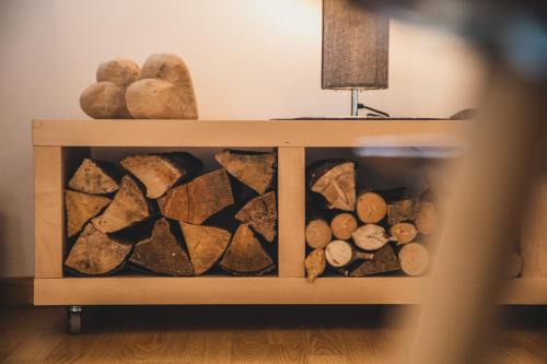 a wooden shelf with logs and rocks on it at Ferienwohnungen Wiesbauer in Schenna