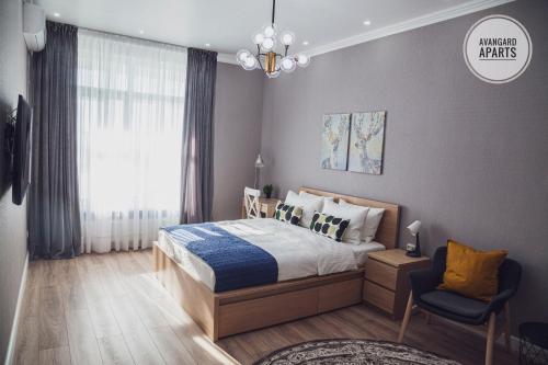 - une chambre avec un lit, une chaise et une fenêtre dans l'établissement Avangard Aparts - Zaman-2, à Atyraū