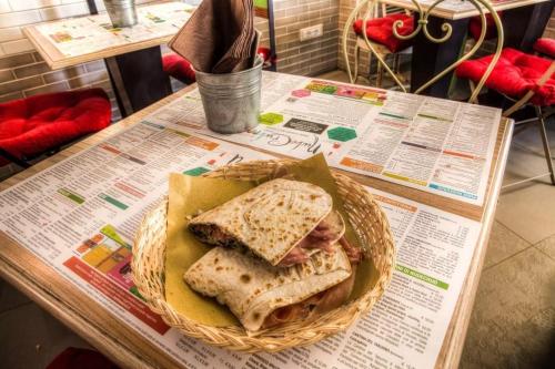 a sandwich in a basket on a table at Hotel Giulio Cesare in Rimini