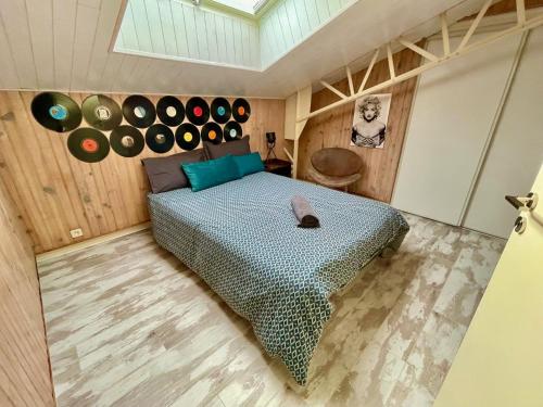 a bedroom with a bed and records on the wall at Superbe LOFT centre-ville - Sauna - parking privé -Clim- 1 à 10personnes in Brive-la-Gaillarde