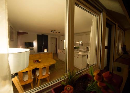 a view of a kitchen and a dining room with a table at Le Cocon du Village Gérardmer in Gérardmer