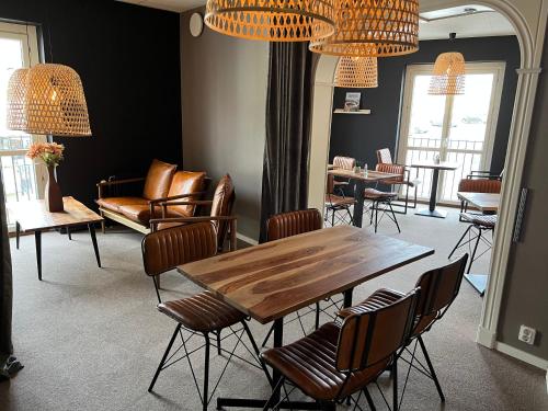 a dining room with a table and chairs and chandeliers at Hotell Siesta in Karlskrona