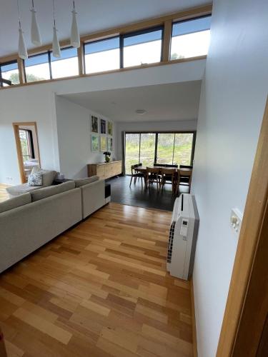 a living room with a couch and a table at Hill Top Retreat in Nubeena