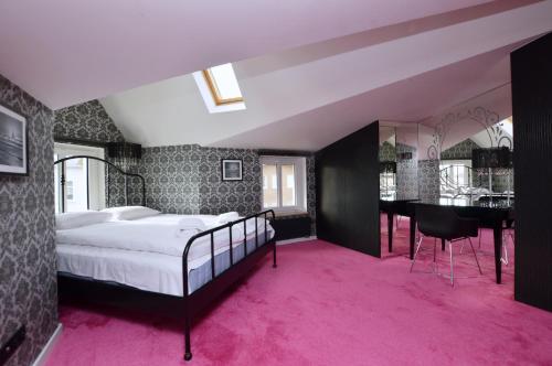 a bedroom with a bed and a pink carpet at Victus Apartamenty, Apartament Aura in Sopot