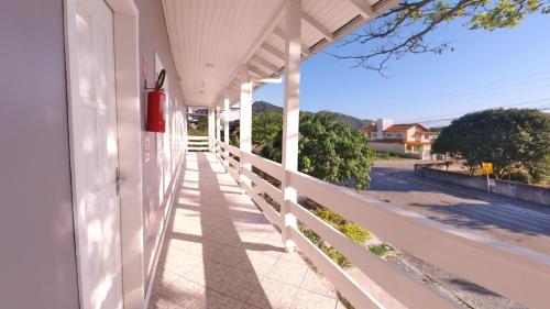 une terrasse couverte d'une maison avec une clôture blanche dans l'établissement Hotel Pousada Ilha do Mar Bombinhas, à Bombinhas