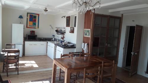eine Küche und ein Esszimmer mit einem Holztisch in der Unterkunft Grand-Varennes in Serbonnes