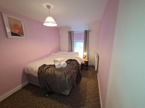 a small bedroom with two beds and a window at Charming Cottage style 3 bedroom property in Merthyr Tydfil