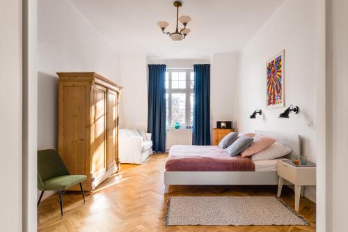 ソポトにあるSanhaus Apartments - 13 Chopina Streetのベッドルーム1室(ベッド1台、椅子、窓付)