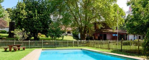 a swimming pool with a bench and a fence at Kings Lodge Hotel in Hogsback
