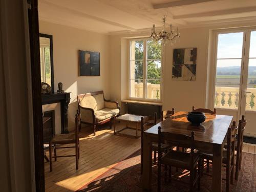 un salon avec une table et des chaises et une cheminée dans l'établissement Grand-Varennes, à Serbonnes