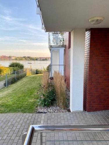 a building with a view of a river and a house at Apartament Promenada II in Ostróda