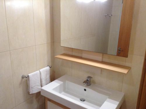 uma casa de banho com um lavatório branco e um espelho. em Ramalho Apartments T3 Cidade Ponta Delgada em Ponta Delgada