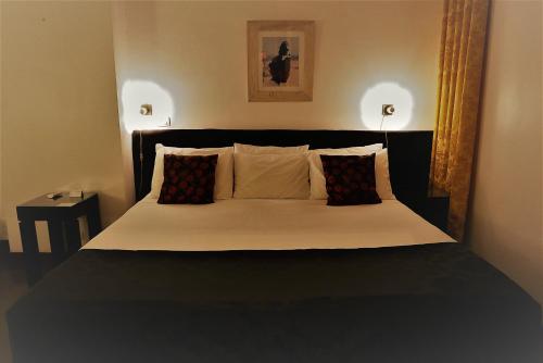 a bedroom with a large bed with two pillows at Aram Yamí Boutique Hotel in Salvador