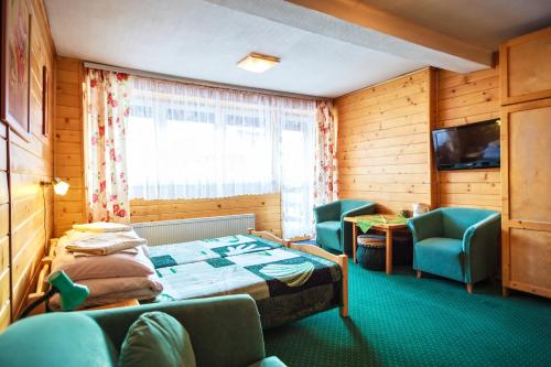 una camera d'albergo con letto, sedie e TV di OSW Moszczeniczanka a Zakopane