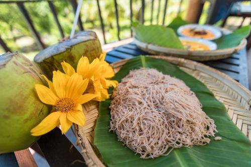 a plate of food with a flower on a banana leaf at Rock Violet Lakefront Cabanas & Restaurent in Tangalle