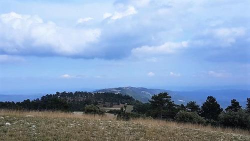 a field with a house in the middle of a hill at nid2nuit Nuance d'Ocres in Apt
