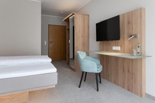 Habitación con cama y escritorio con TV. en Hotel Grosse Klus en Bückeburg
