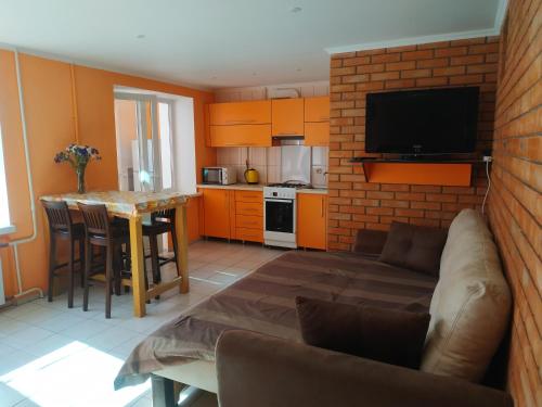 Una sala de estar con un sofá y una cocina con una mesa. en Солнечное настроение, en Vínnytsia