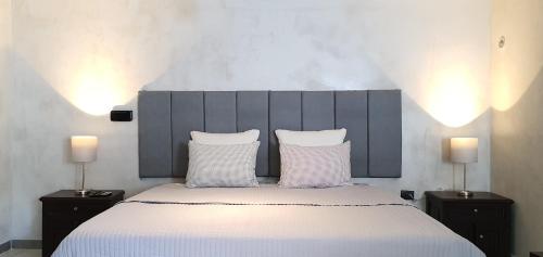 um quarto com uma cama grande com lençóis brancos e 2 candeeiros em Cozumel 568 - Vacation Rental em Cozumel