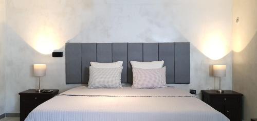 a bedroom with a large bed with white sheets and two lamps at Cozumel 568 - Vacation Rental in Cozumel