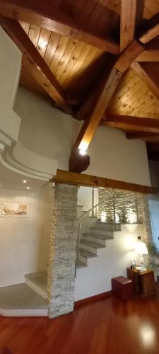 a living room with a staircase and a stone wall at Villa Laura B&B in Fossano