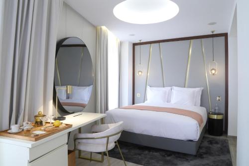 a bedroom with a bed and a desk and a mirror at São Vicente Alfama Hotel by TRIUS Hotels in Lisbon