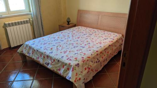 una camera da letto con un letto con una coperta a fiori di Ericeira II - Apartment with Pool - Horizonte Mar a Ericeira