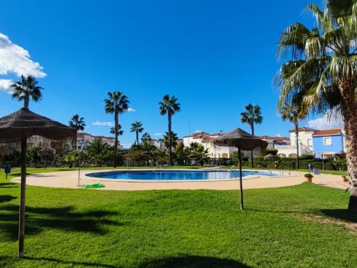 a park with a swimming pool and palm trees at El Mirador de Torremari - Nudista - Vera playa in Vera