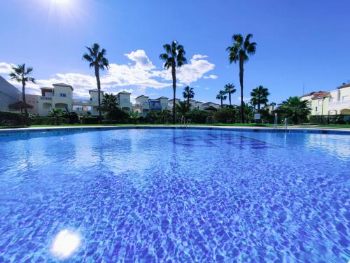 een groot zwembad met palmbomen op de achtergrond bij El Mirador de Torremari - Nudista - Vera playa in Vera