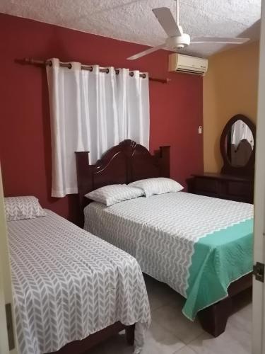 a bedroom with two beds and a ceiling fan at Las colinas de Samaná in Santa Bárbara de Samaná