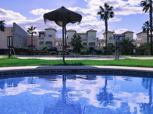 a large swimming pool with an umbrella in front of a building at El Mirador de Torremari - Nudista - Vera playa in Vera