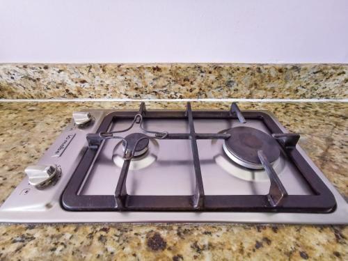 a stove top with a pot and tongs on it at Estudio 310 Nuevo Vallarta, frente al mar, totalmente equipado y amueblado! in Nuevo Vallarta 